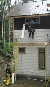 Eddie and Shawn putting siding on the back of the house